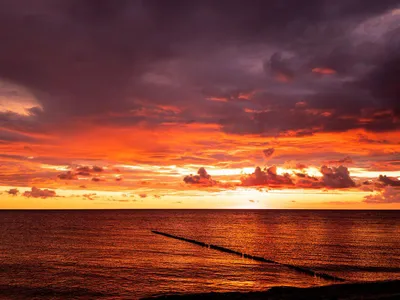 Wandbild und Fototapete mit einem Landschaftsmotiv mit dem Titel Himmelsglühen - Sonnenuntergang am Meer in der Max Steinwald Art Galerie