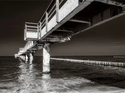 Wandbild und Fototapete mit einem Motiv der nicht mehr existierenden alten Seebrücke von Koserow als schwarz weiß Fotografie mit dem Titel Alte Seebrücke Koserow-schwarz-weiss in der Max Steinwald Art Galerie